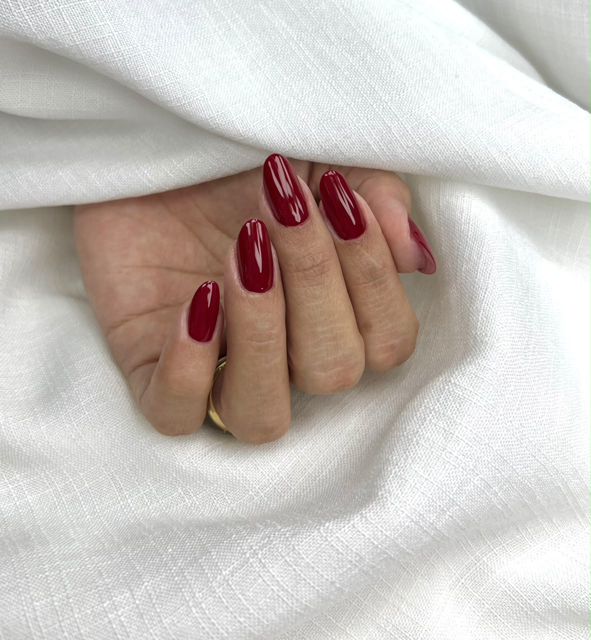 Unhas ovais vinho com brilho intenso feitas por Ana Amélia