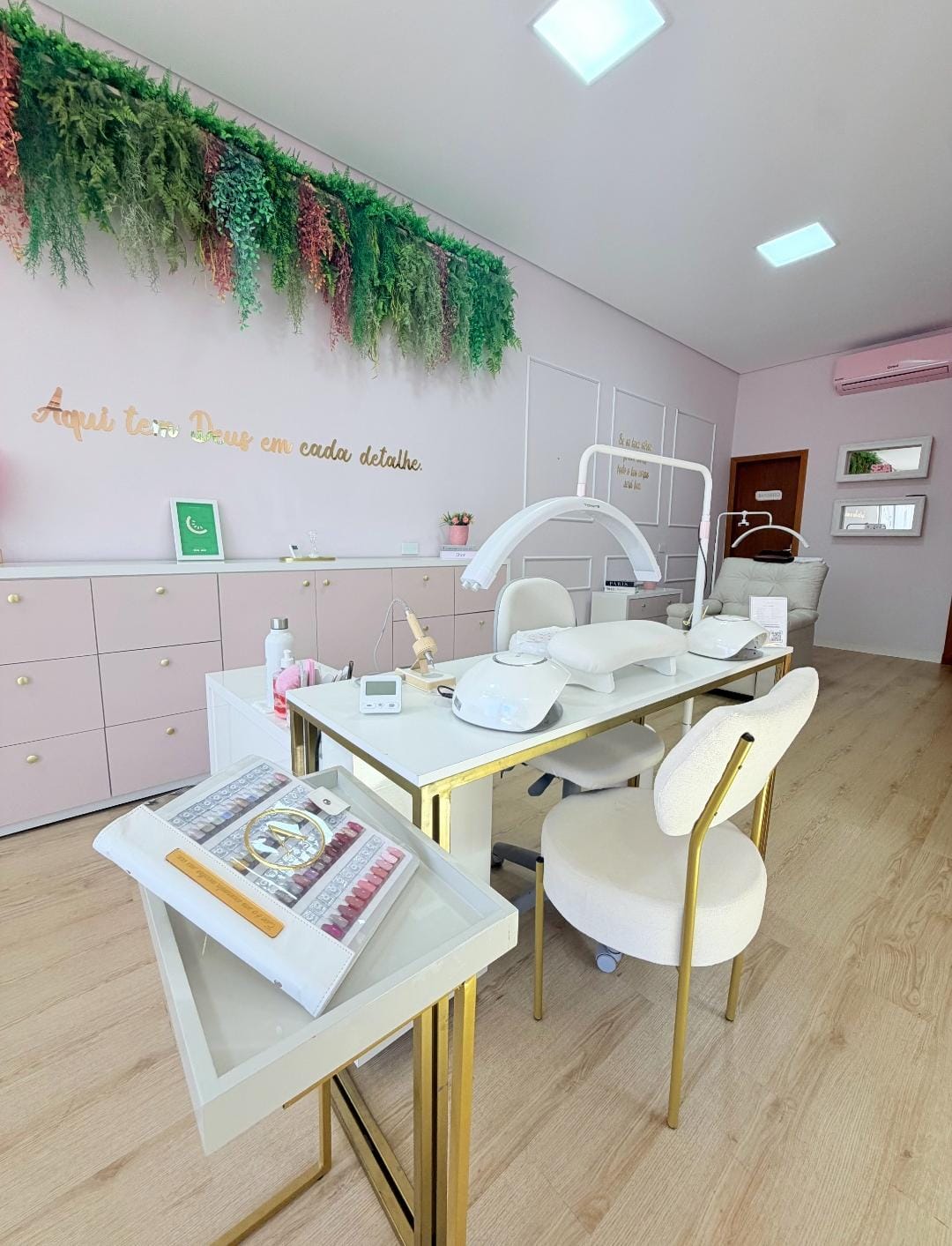 Sala de atendimento com mesa de manicure e detalhes dourados
