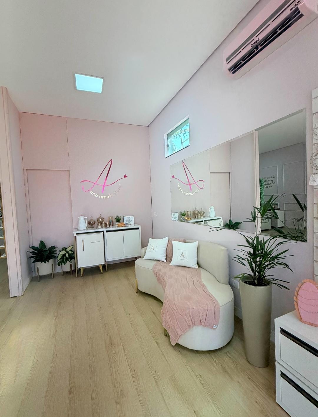 Lounge de espera com sofá creme e manta rosé