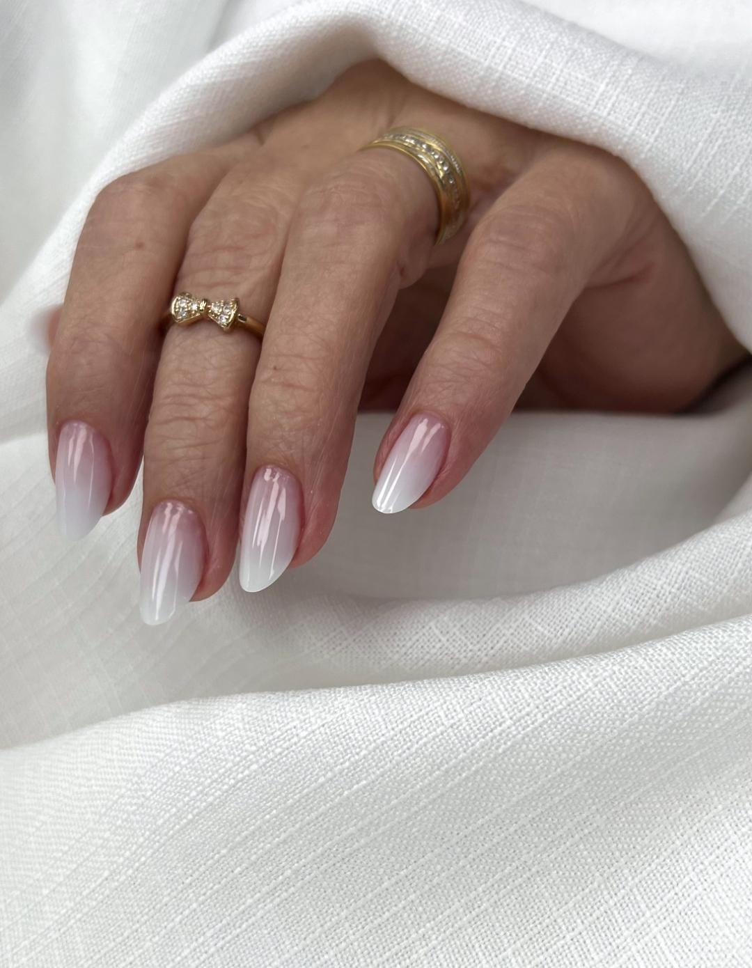 Unhas degradê branco leitoso em formato amendoado